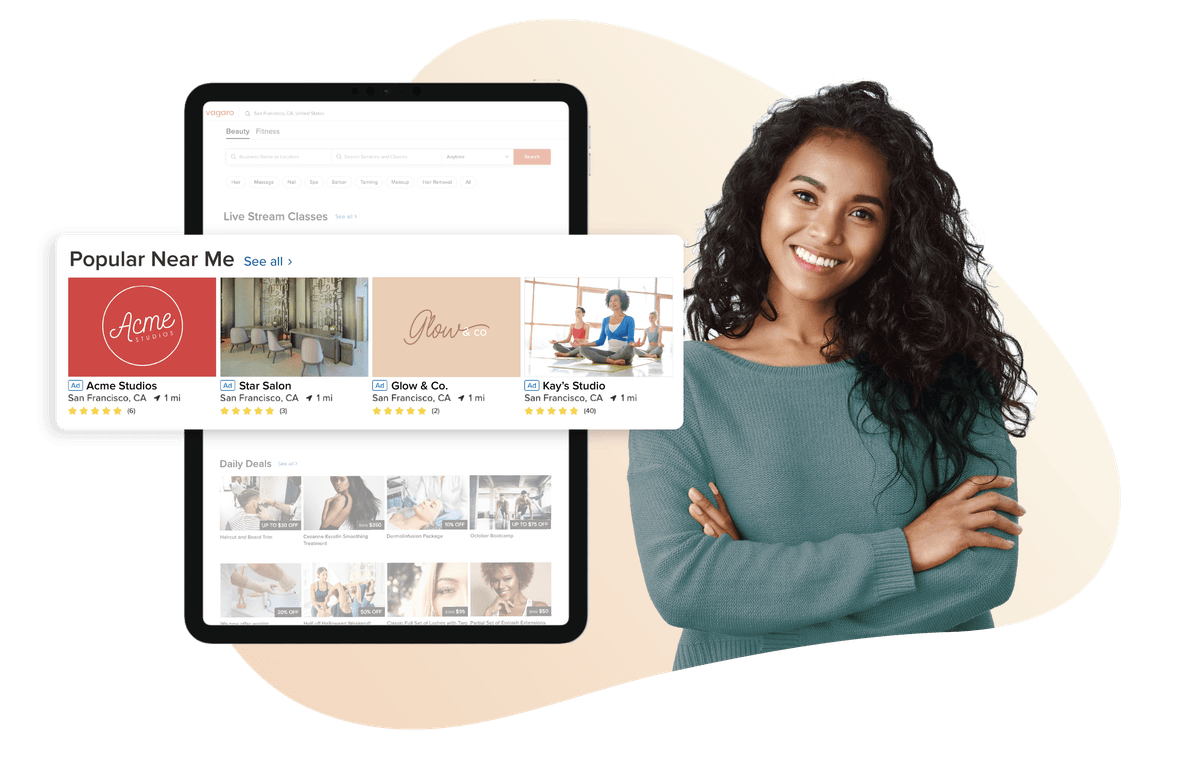 A picture of a woman stood next to a tablet that shows our Get Featured section in the Vagaro marketplace.